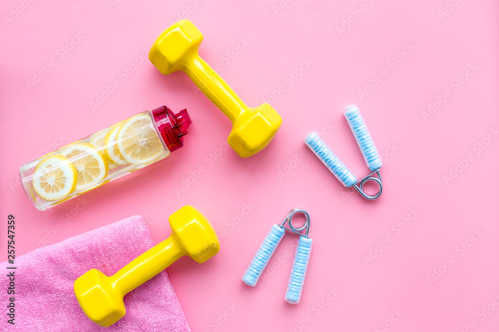 Fitness background with sport equipment for gym and home on pink background top view