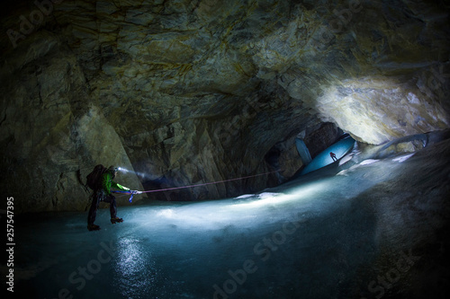 Two men climbing while exploring cave of Booming Ice Chasm, Crowsnest Pass, Alberta, Canada photo