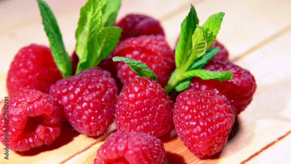 Red raspberries with mint on the wooden box. Fresh raspberry fruits as food background. Healthy food organic nutrition. Close up. 4K Red raspberries with mint on the wooden box. Fresh raspberry fruits as food background. Healthy food organic nutrition. Close up. 4K