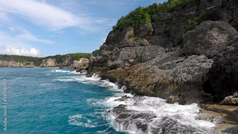 Spectacular aerial shot over waves crashing into a rocky shoreline Spectacular aerial shot over waves crashing into a rocky shoreline