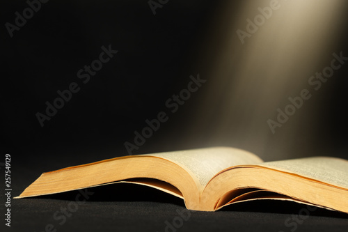 Open book with light beam and copy space