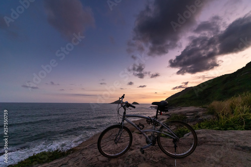 bicycle with the background a multicolored sunset at the lookout for beach in rio de janeiro brazil