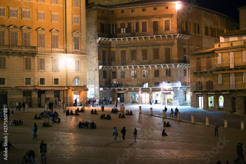 Tourists in Piazza del Campo by night, Siena, Italy. The historic centre of Siena. UNESCO World Heritage Site