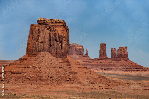 Monument Valley famous rock formations under a blue sky.