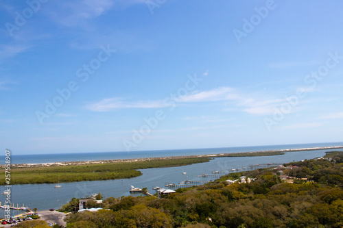 Looking from a high point down into an inlet with islands, a blue sky and whispy white clouds