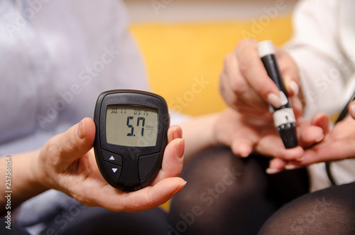 Woman holding sugar measurement instrument - showing good glucose level 