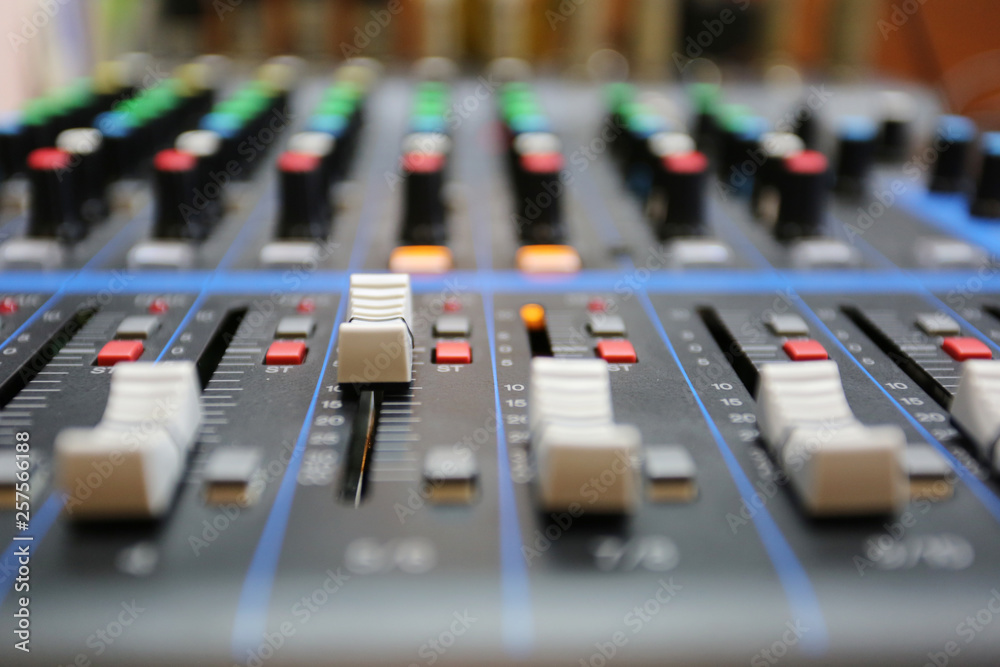 Audio mixer control panel with buttons and sliders.