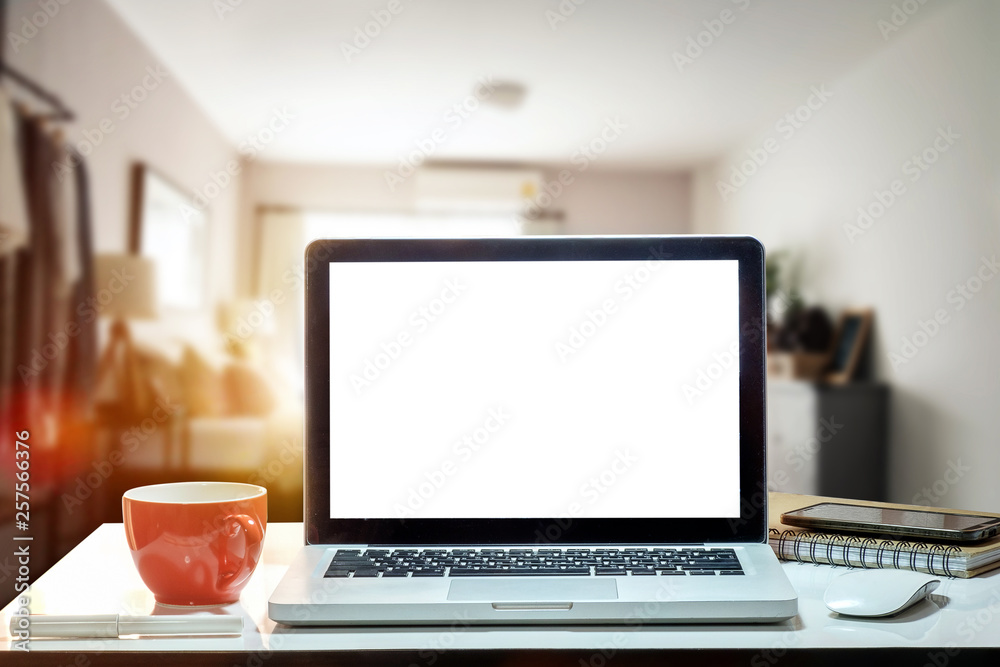 Fototapeta premium Front view of cup and laptop, smartphone, and tablet on table in office and background 