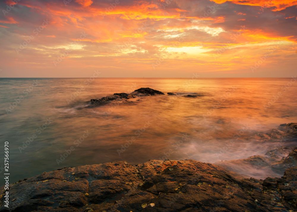 Naklejka premium Beautiful Tropical seascape wave hit the rock during sunset