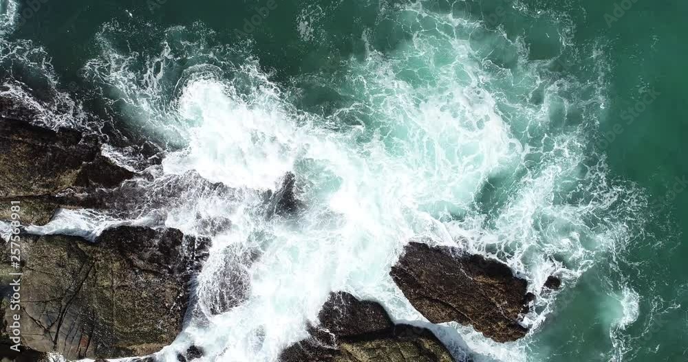 Top view water splashing on the rocky shore with splash drone 4k Top view water splashing on the rocky shore with splash drone 4k
