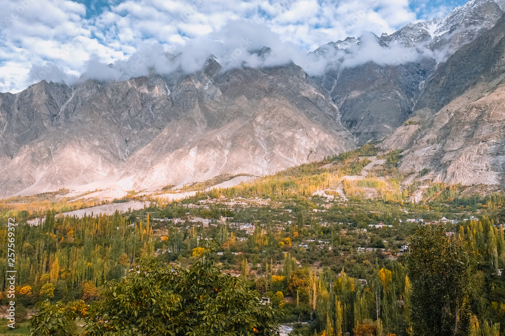 Hunza valley in autumn. Morning sunlight lit the forest and mountains in Karakoram range. Gilgit Baltistan, Pakistan.