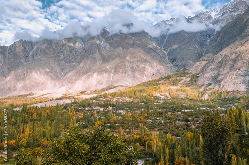 Hunza valley in autumn. Morning sunlight lit the forest and mountains in Karakoram range. Gilgit Baltistan, Pakistan.