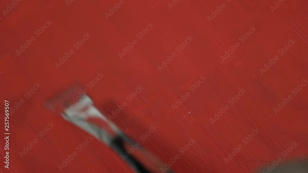 Paint Brush stroking across red painted surface Paint Brush stroking across red painted surface
