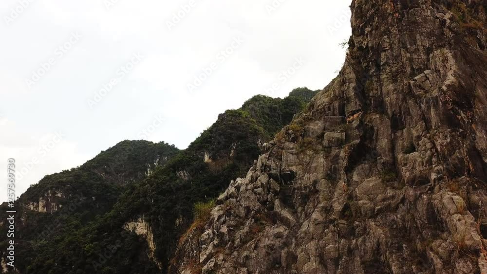 Aerial over the sharp rocky mountains of Tam Cốc-Bích Động then turning to reveal the water Aerial over the sharp rocky mountains of Tam Cốc-Bích Động then turning to reveal the water