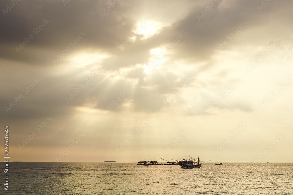 Fishing boat in the sea at sunset sky.