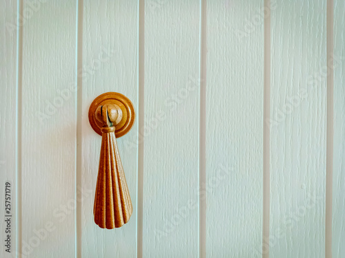 close up on a handle with decorative elements on a white wooden background, vintage