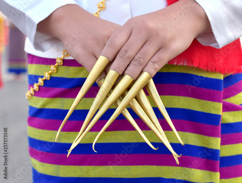 Close up image of northern Thailand woman dress her fingers with golden metal as fingernails like a claws in Lanna Thai traditional nail dancing performance, nail dance, Lanna nail dancing performance