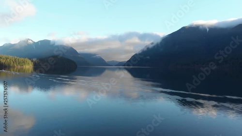 4K drone shot over glistening lake in Canada with mountains in the background. photo