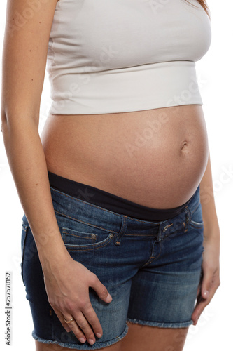 Belly of a pregnant woman. Term 6 months, close-up. Isolated on white background. © Анна Демидова