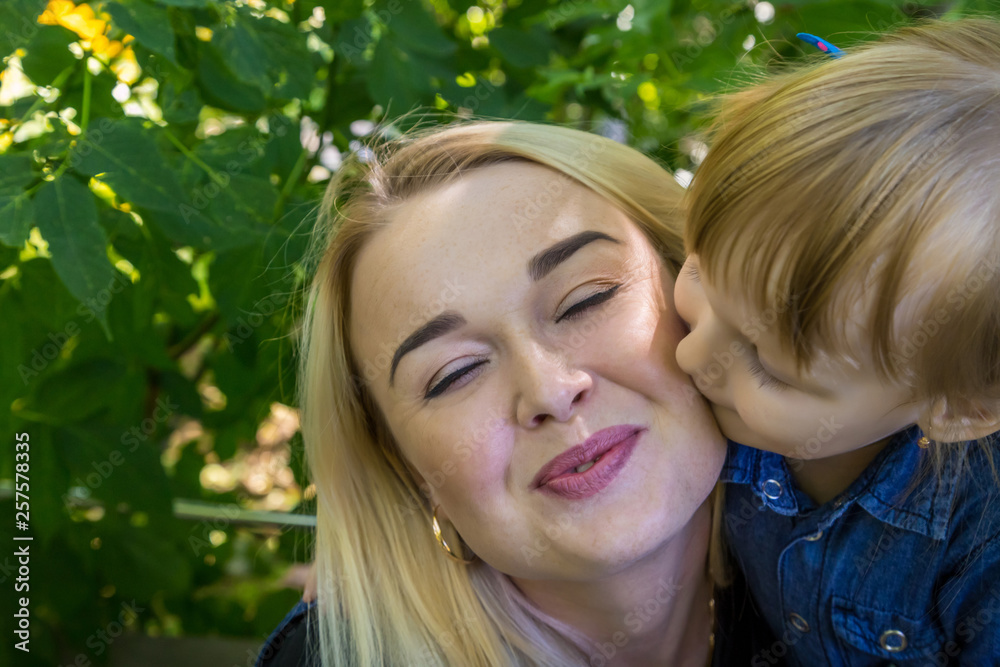 Cute blonde woman and her daughter in the park