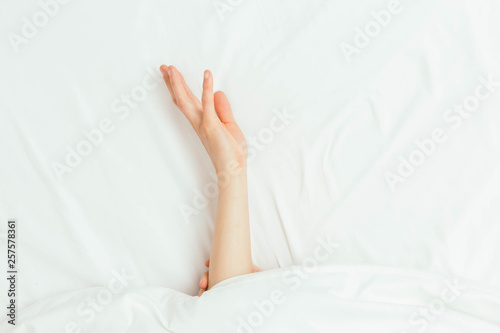 Caucasian Hands Peeking Out From Under Bedsheets