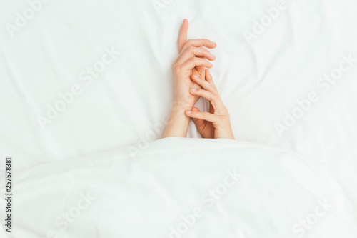 Caucasian Hands Peeking Out From Under Bedsheets
