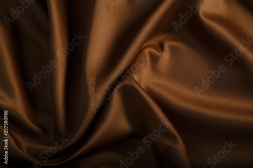 Smooth elegant brown silk or satin texture can use as abstract background. Luxurious background design wallpaper