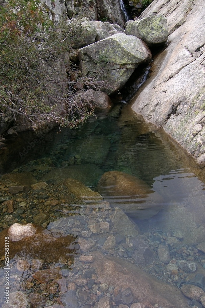 A small natural pool with crystal clear water in the mountains of Corsica