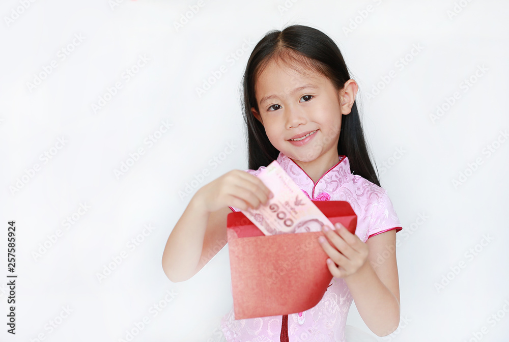 Happy little Asian child girl wearing pink traditional cheongsam dress smiling while receiving Chinese New Year red envelope packet with money on white background. Happy chinese new year concept. Happy little Asian child girl wearing pink traditional cheongsam dress smiling while receiving Chinese New Year red envelope packet with money on white background. Happy chinese new year concept.