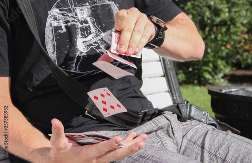 The beautiful magician goes through the cards in his hands and does magic tricks