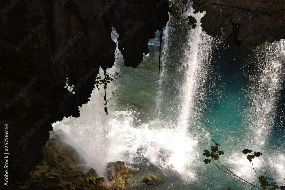 waterfall with azure water with a view from under the rocks