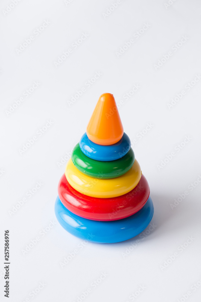 Pyramid build from colored rings with a clown head on top. Toy for babies and toddlers to joyfully learn mechanical skills and colors. Studio shot on white background. Pyramid build from colored rings with a clown head on top. Toy for babies and toddlers to joyfully learn mechanical skills and colors. Studio shot on white background.