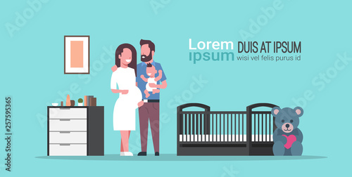 husband with pregnancy wife holding newborn baby son standing near crib happy family parenthood concept modern baby's bedroom interior flat full length copy space