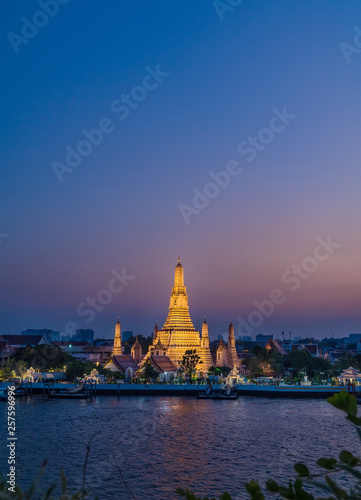 Night photo illuminated old Wat Arun Ratchawararam Ratchawaramahawihan or Wat Arun "Temple of Dawn" - Buddhist temple in Bangkok Yai district, Thailand, on the Thonburi bank of Chao Phraya River © Train arrival
