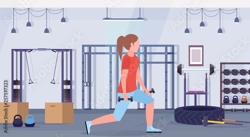 sporty woman doing squats with dumbbells girl training in gym buttocks workout healthy lifestyle concept modern health club studio interior horizontal