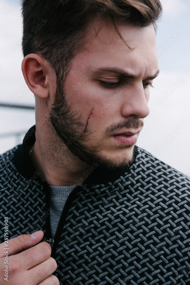 A man in a gray jumper with a zipper posing. Advertising of men's clothing. A man in a gray jumper with a zipper posing. Advertising of men's clothing.