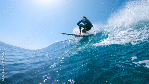LOW ANGLE  Fit male tourist riding a big blue barrel wave during his vacation.