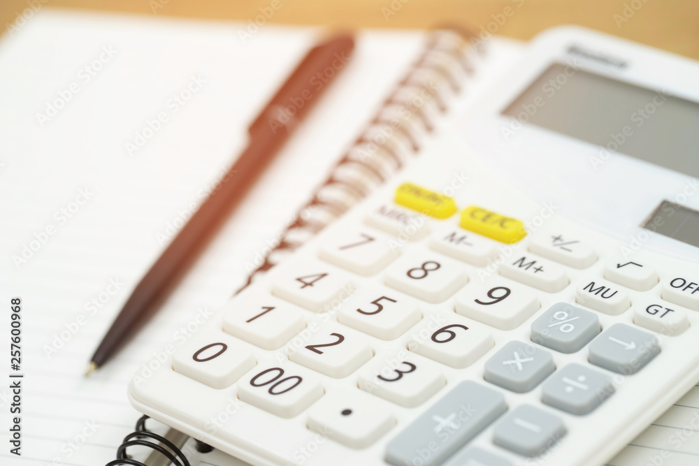 Office desk table calculator with notepad book and black pen. Top view with copy space. investment calculation Accounting, financial concept Office desk table calculator with notepad book and black pen. Top view with copy space. investment calculation Accounting, financial concept