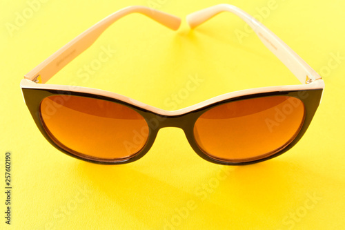 Sunglasses on yellow background. The concept of summer.