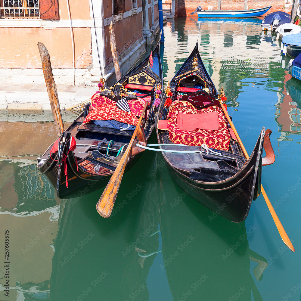 Gondola - symbol of Venice, narrow side channel, Venice, Italy. Gondola is iconic traditional boat, very popular means of transport for tourists