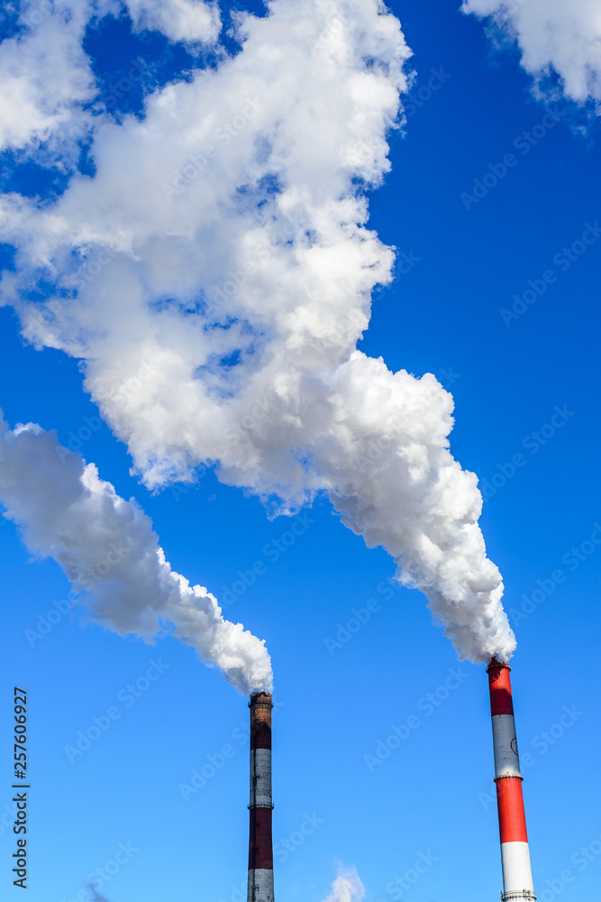 white smoke from the chimney against the blue sky, heavy industry