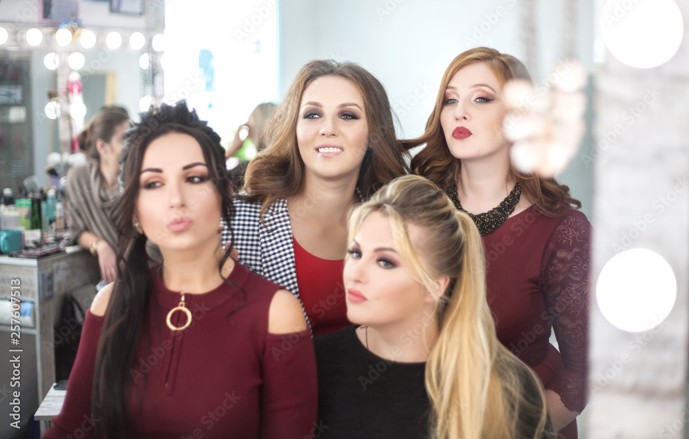Four young women looking in the mirror in the beauty salon. Four young women looking in the mirror in the beauty salon.