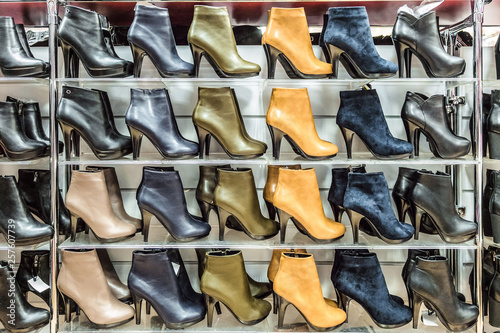 Multi-storey rows of womens seasonal boots. Shoes store.