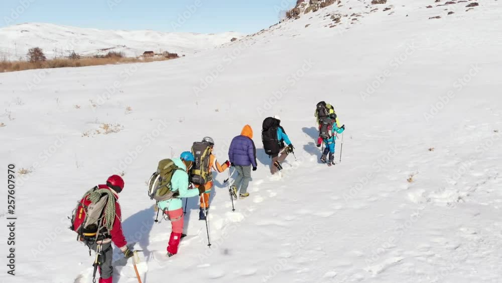 a group of climbers hung a special ammunition overcome deep snowdrifts lying in front of a huge hill on which people are going to rise