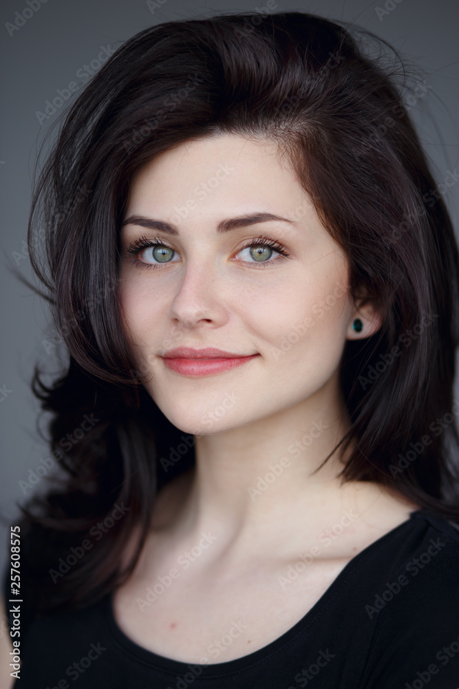 Cute brunette girl with beautiful green eyes,wavy hair with volume looks at camera and smiles sweetly and innocent. Cute brunette girl with beautiful green eyes,wavy hair with volume looks at camera and smiles sweetly and innocent.