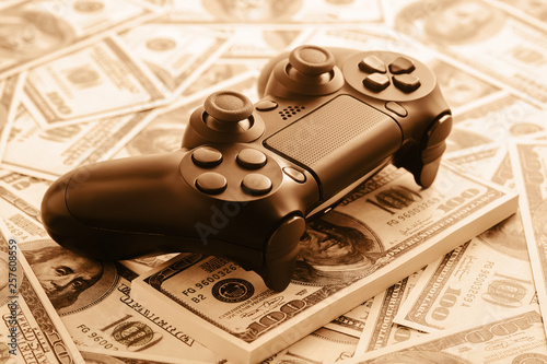 Concept of gaming addtion. Close up photo of gamepad on the money background. photo