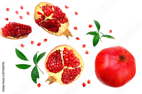piece of pomegranate with seeds and green leaves isolated on a white background. top view