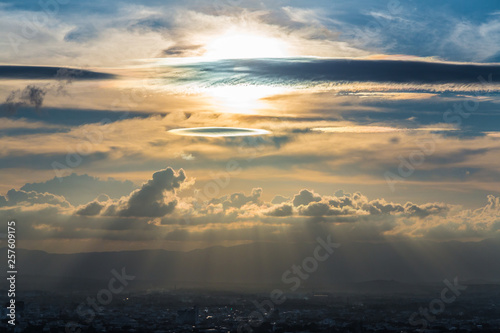 Beautiful clouds with sunshine passing through the sky at sunset. © Attapol