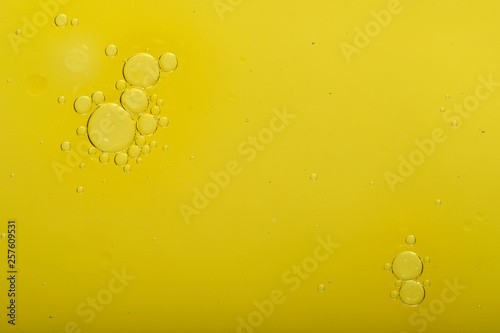 Abstract blurred gentle background. Fluid texture with circles and bubbles of yellow color. Cropped shot, macro, horizontal, nobody, free space for text.