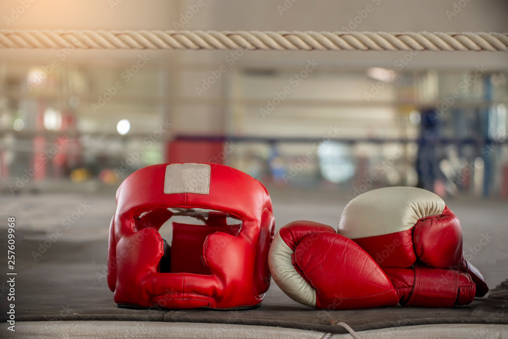 Boxing Headquard and leather mitt glove placed on canvas of ring in
